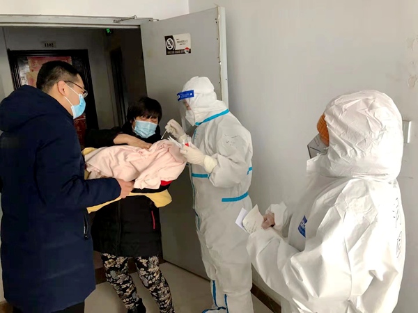 农工党石家庄市平安医院支委会党员在入户为婴儿做核酸检测.jpg